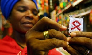 Una mujer sudafricana, teje un lazo contra el sida en un mercado de Johannesburgo. EFE
