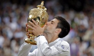 El serbio Novak Djokovic besa el trofeo obtenido al ganar al español Rafael Nadal en el partido final del campeonato de tenis de Wimbledon, en Londres. Foto: Kerim Okten / EFE