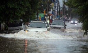 Varios carros transitan por una calle inundada, tras las lluvias de la tormenta tropical "Emily" en Santo Domingo (República Dominicana). Foto: Orlando Barría / Efe