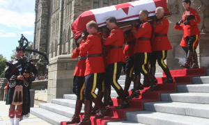Ocho miembros de la Real Policía Montada portan el féretro de Jack Layton, saliendo del Parlamento, en Ottawa