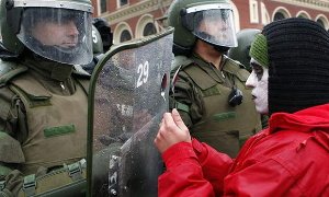 Un manifestante toca el escudo de un carabinero durante una marcha de protesta en Santiago de Chile. Foto: Felipe Trueba / Efe