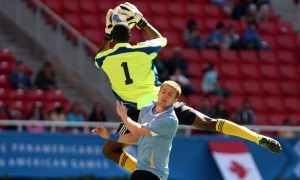 El uruguayo Adrian Gunino disputa el balón con el trinitario Andre Marchan, durante uno de los partidos por la primera fase del fútbol de los Juegos Panamericanos 2011. Foto: Alex Cruz / Efe