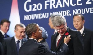 El presidente estadounidense, Barack Obama, observa la amapola en el ojal del primer ministro canadiense, Stephen Harper, con la que recuerda a los caídos en las dos grandes guerras mundiales del siglo XX, durante la foto de familia de la sexta Cumbre de los líderes del G20 celebrada en Cannes, Francia. Foto:/Chris Ratcliffe / Efe