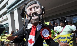 Un manifestante en Durban (Suráfrica), con una máscara del primer ministro canadiense, Stephen Harper, durante los actos de protesta contra la falta de acciones eficaces contra el cambio climático. Foto: AFP