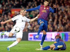 El delantero francés del Real Madrid, Karin Benzemá (i), golpea el balón para conseguir el segundo gol del equipo blanco, ante los defensas del FC Barcelona, Gerard Piqué (c) y Carles Puyol, durante el partido de vuelta de los cuartos de final de la Copa del Rey, que han disputado este miércoles en el Nou Camp, en Barcelona.
