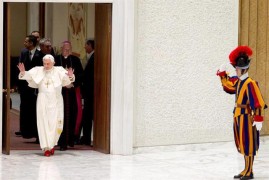 CIUDAD DEL VATICANO.- Un guardia suizo (dcha) saluda al papa Benedicto XVI (izda) a su llegada a la audiencia pública de los miércoles en el Aula Pablo VI en la Ciudad del Vaticano.