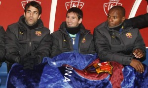 Los jugadores del FC Barclelona Cesc Fábregas, Leo Messi y Eric Abidal se protegen con una manta en el banquillo, antes de comenzar el partido de vuelta de los octavos de final de la Copa del Rey, que Osasuna y FC Barcelona disputaron en el estadio Reyno de Navarra, en Pamplona, España. El Barcelona venció por 1-2. Foto: Jesús Diges / Efe