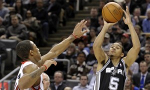 Cory Joseph, de los Spurs de San Antonio, lanza a canasta ante DeMar DeRozan, de los Raptors de Toronto