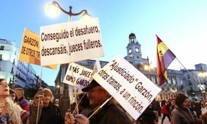 Varios manifestantes exhiben pancartas a favor del juez Baltasar Garzón este lunes en la Puerta del Sol, en Madrid, después de que el Tribunal Supremo le haya absuelto de prevaricación en la causa del franquismo. Foto: Alberto Martín / Efe