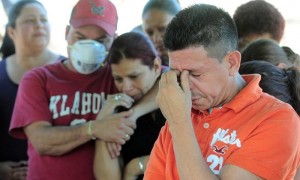 Familiares de Marvin Javier Muñoz, uno de los reos que murió debido al incendio en la Granja Penal de Comayagua, asisten a su entierro, este viernes 17 de febrero de 2012, en un cementerio de Tegucigalpa. La Granja Penal de Comayagua, en la que el martes murieron más de 350 presos en un incendio, por muchos años fue considerada una cárcel modelo en la que los reos cultivaban la tierra, criaban cerdos, gallinas y peces para su sustento y todavía les quedaba para vender en el mercado local. Foto: Gustavo Amador / Efe