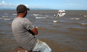 Una persona observa el operativo de rescate al naufragio de una frágil embarcación ocurrido en las costas del noreste dominicano. Foto: Orlando Barría / Efe