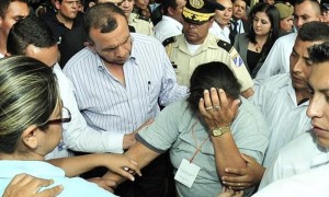 El presidente de Honduras, Porfirio Lobo, habla con Petrona Morena, madre de un recluso que falleció en el incendio de la granja penal de Comayagua, tras desmayarse durante la visita del mandatario al Instituto Nacional de Informacion Profesional (INFOP) en Tegucigalpa (Honduras), donde permanecen hospedados familiares de los reclusos cuyos cuerpos aún no han sido identificados. Foto: Gustavo Amador / Efe