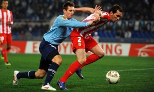 El delantero alemán del SS Lazio Miroslav Klose lucha por el balón con el defensa uruguayo del Atlético de Madrid Diego Godín, durante el partido de ida de los dieciseisavos de final de la Liga Europa, jugado en el estadio Olímpico de Roma. Foto: Andrea Staccioli / Efe