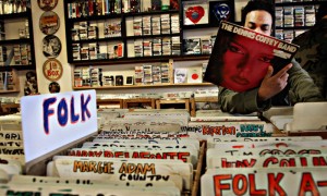 Un cliente consulta la sección de vinilos en una tienda de discos.