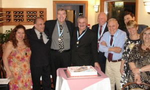 Los 9 pioneros que todavía juegan en la liga Palo Uno rodean la torta de aniversario.
