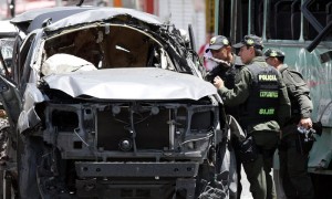 BOGOTÁ (COLOMBIA).- Policías inspeccionan los vehículos afectados por la explosión de una bomba que causó la muerte a varias personas este martes, en Bogotá.