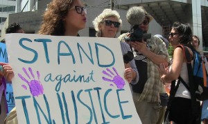 Joven manifestante sostiene pancarta " Estamos en contra de la injustica"
