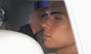 MONTREAL.- Imagen en la que aparece el modelo y actor porno Luka Rocco Magnotta (centro), sospechoso de haber asesinado, descuartizado y comido partes del cuerpo de un estudiante chino, dentro de un vehículo policial a su llegada a Montreal.
