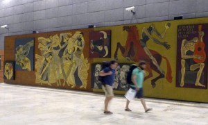 MADRID.- Imagen facilitada por AENA de dos pasajeros pasando junto al mural de 120 metros pintado por el artista ecuatoriano Oswaldo Guayasamín, que celebró este jueves sus 30 años en el aeropuerto madrileño de Barajas en los que ha sido testigo del tránsito de miles de personas entre España y Latinoamérica.