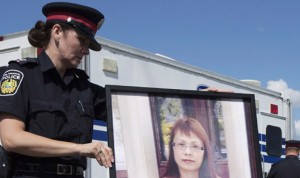 Una agente muestra a los medios una fotografía de la mujer asesinada.