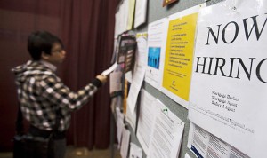 Un joven consulta un cartel con ofertas de empleos