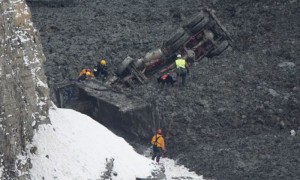 Varios miembros del equipo de rescate llegan hasta uno de los camiones sepultados.